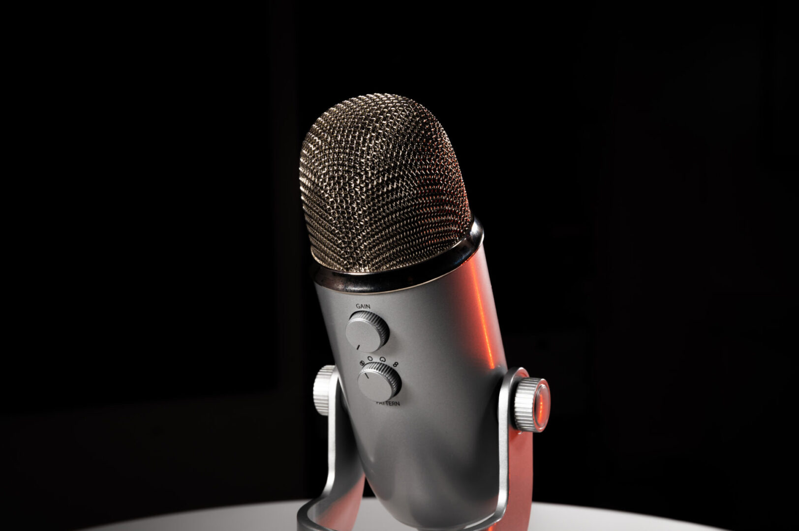 Blue Yeti microphone sitting on a table with a black background